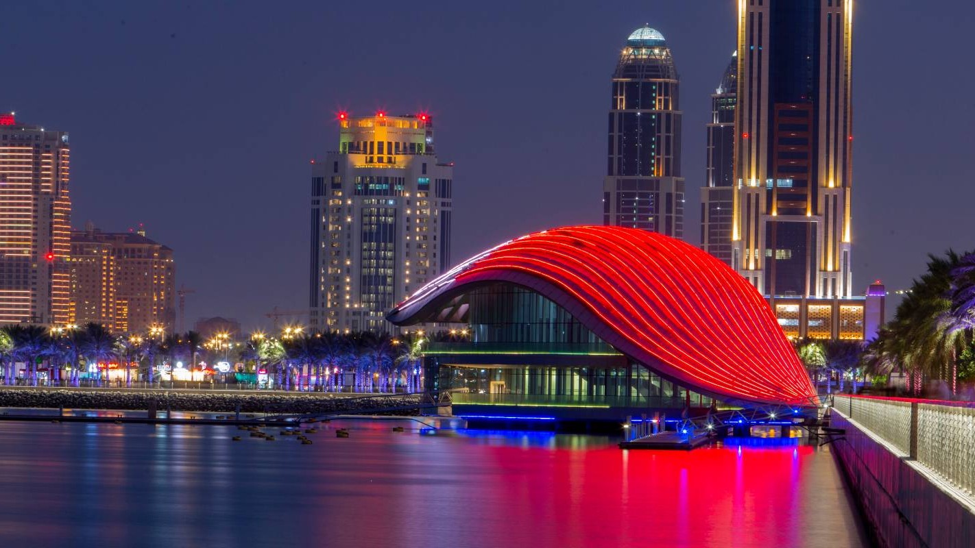 Lusail Marina Yacht Club at night with red-lit canopy